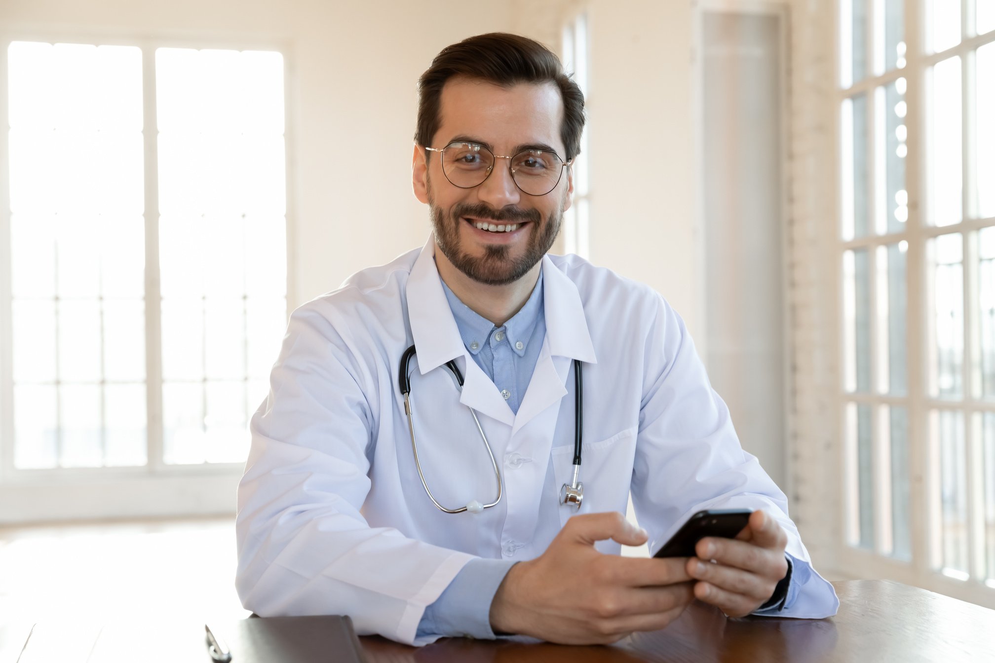 Doctor Sitting at Desk with Phone